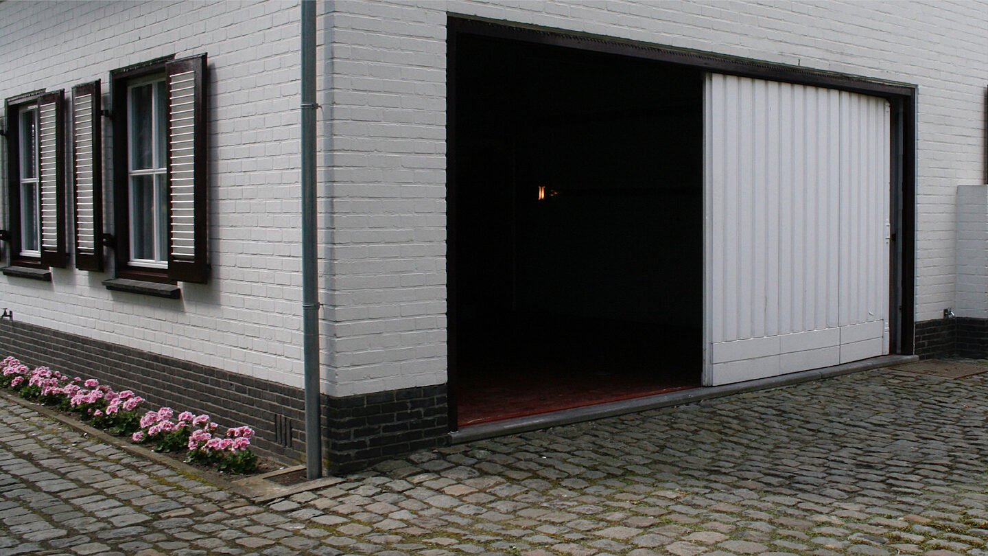 Binnen de gevel blijvende garagepoort horizontaal schuivende panelen buitenzijde header
