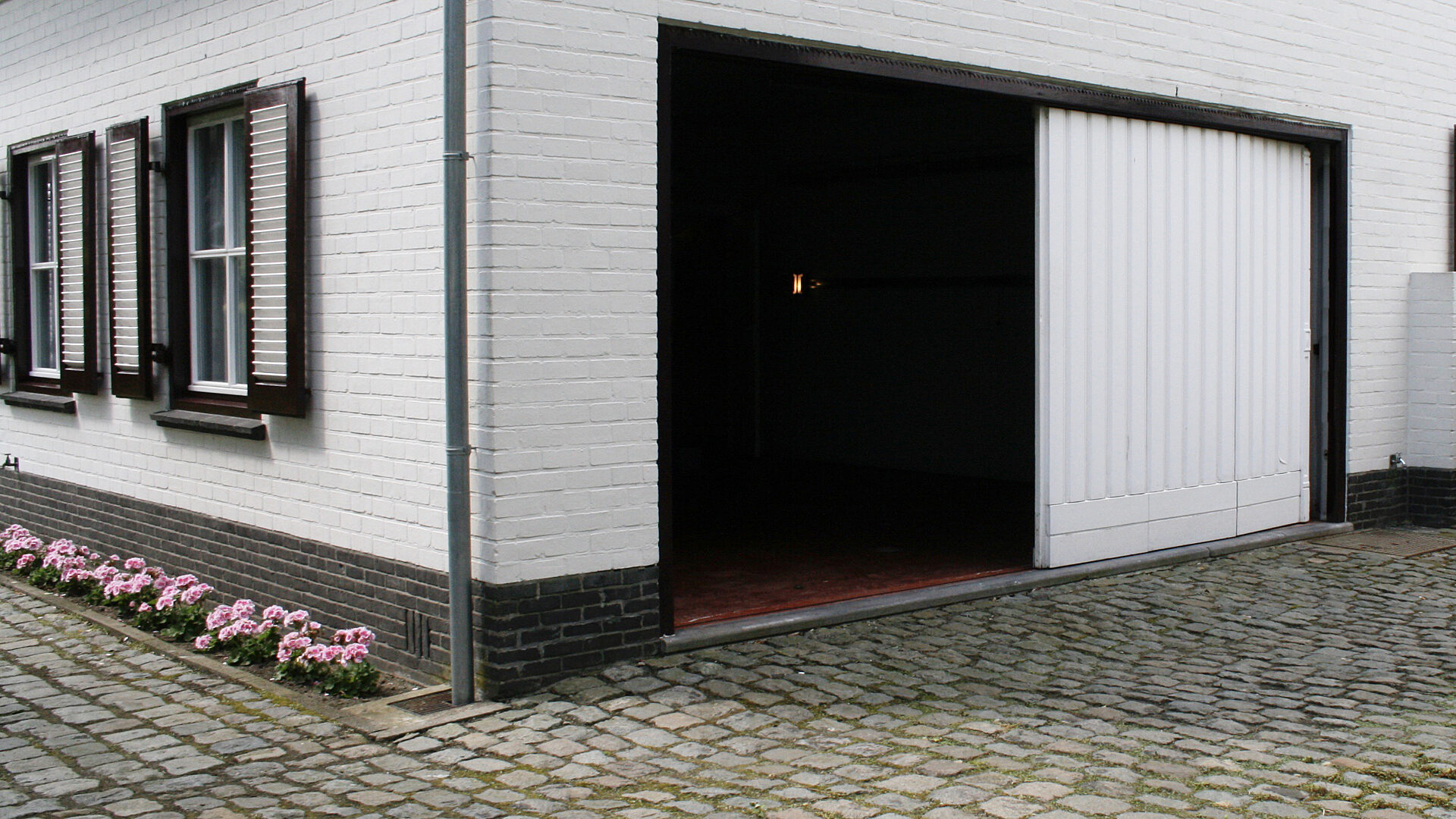 Binnen de gevel blijvende garagepoort horizontaal schuivende panelen open buitenzijde links