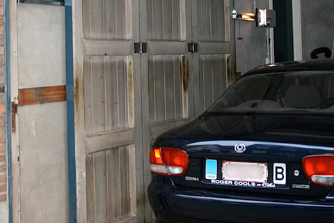 Binnen de gevel blijvende garagepoort schuifpoort open met zicht motor buitenzicht